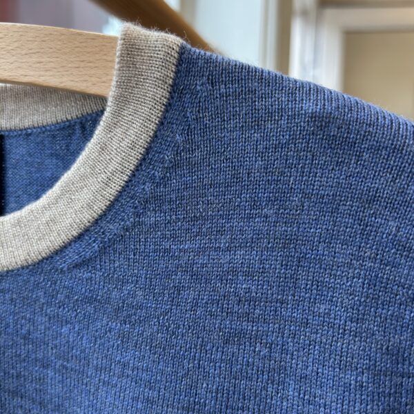 detail Wat no. 3 Knitwear for women - handmade in Italy Detail of blue short-sleeved knit blouse with light beige trim, Danish design.
